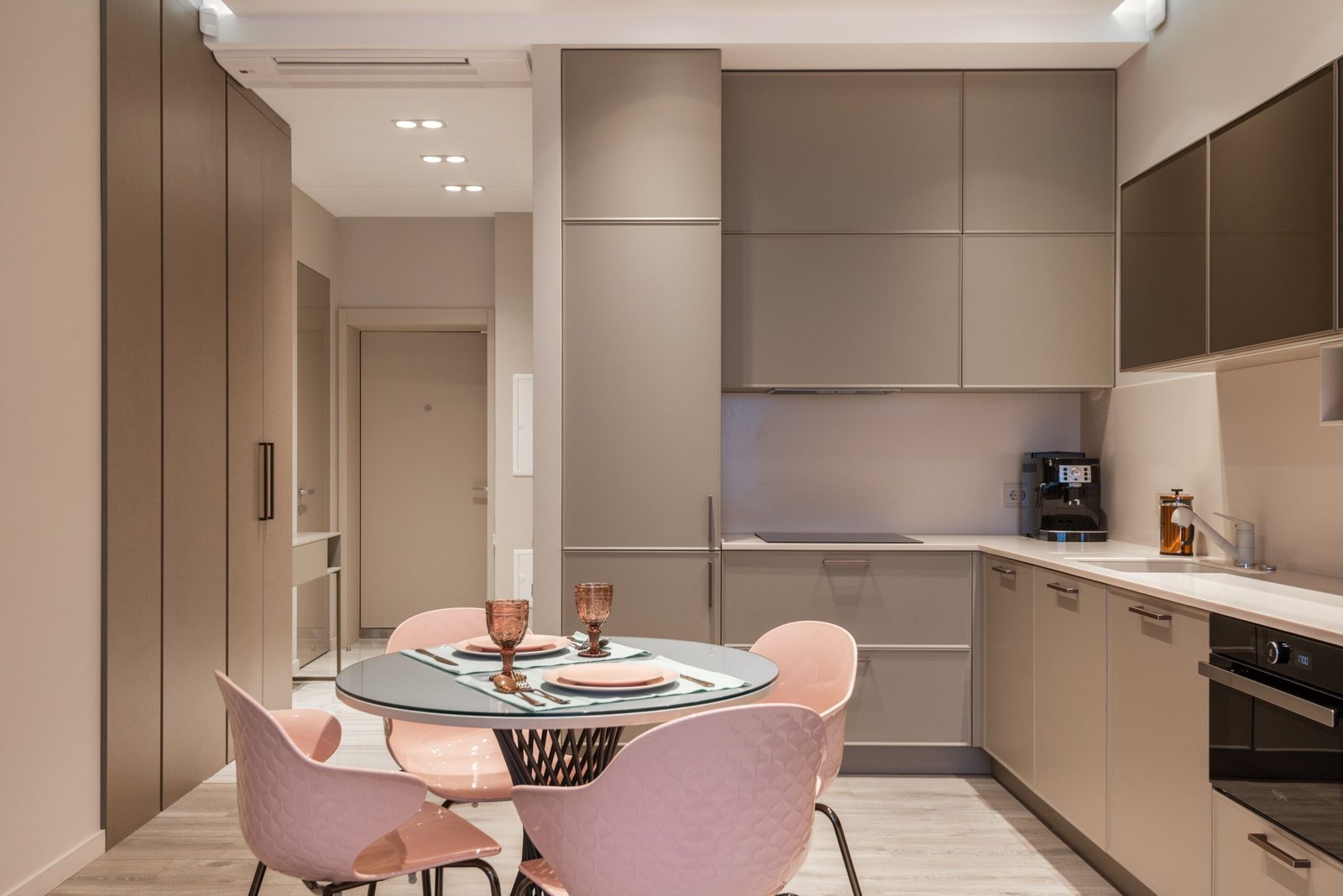 Modern stylish kitchen interior design with empty shelves set dining table and light pink chairs
